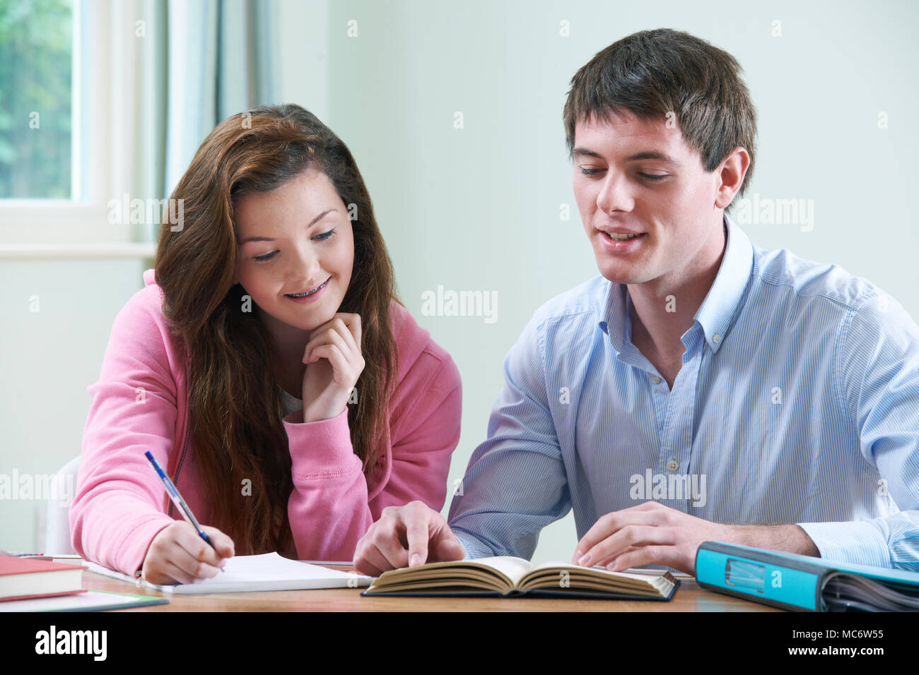 Ragazza adolescente studiando con Home Tutor Foto Stock