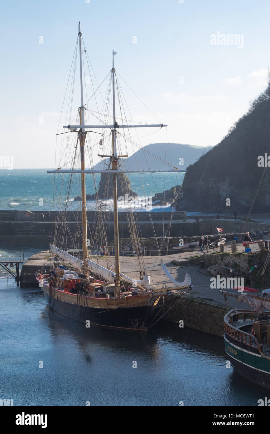 Poldark location del film di Charlestown - due masted vecchie navi a vela nel porto con rocce, il mare e le coste al di là Foto Stock