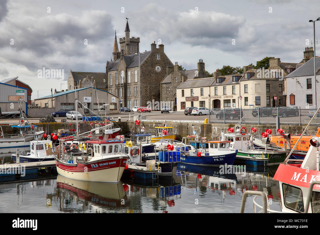 Una collezione di nearshore navi da pesca ormeggiate al porto di Fraserburgh guardando verso la città, Caley Pesca Ltd e Dalrymple Hall Arts Centre Foto Stock