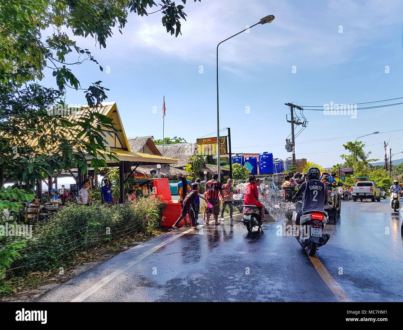 Phuket, Tailandia - 13 Aprile 2018: l'uomo versare acqua sul driver moto celebrare tailandese tradizionale nuovo anno - Songkran Festival. Credito: Anna Moskvina/Alamy Live News Foto Stock