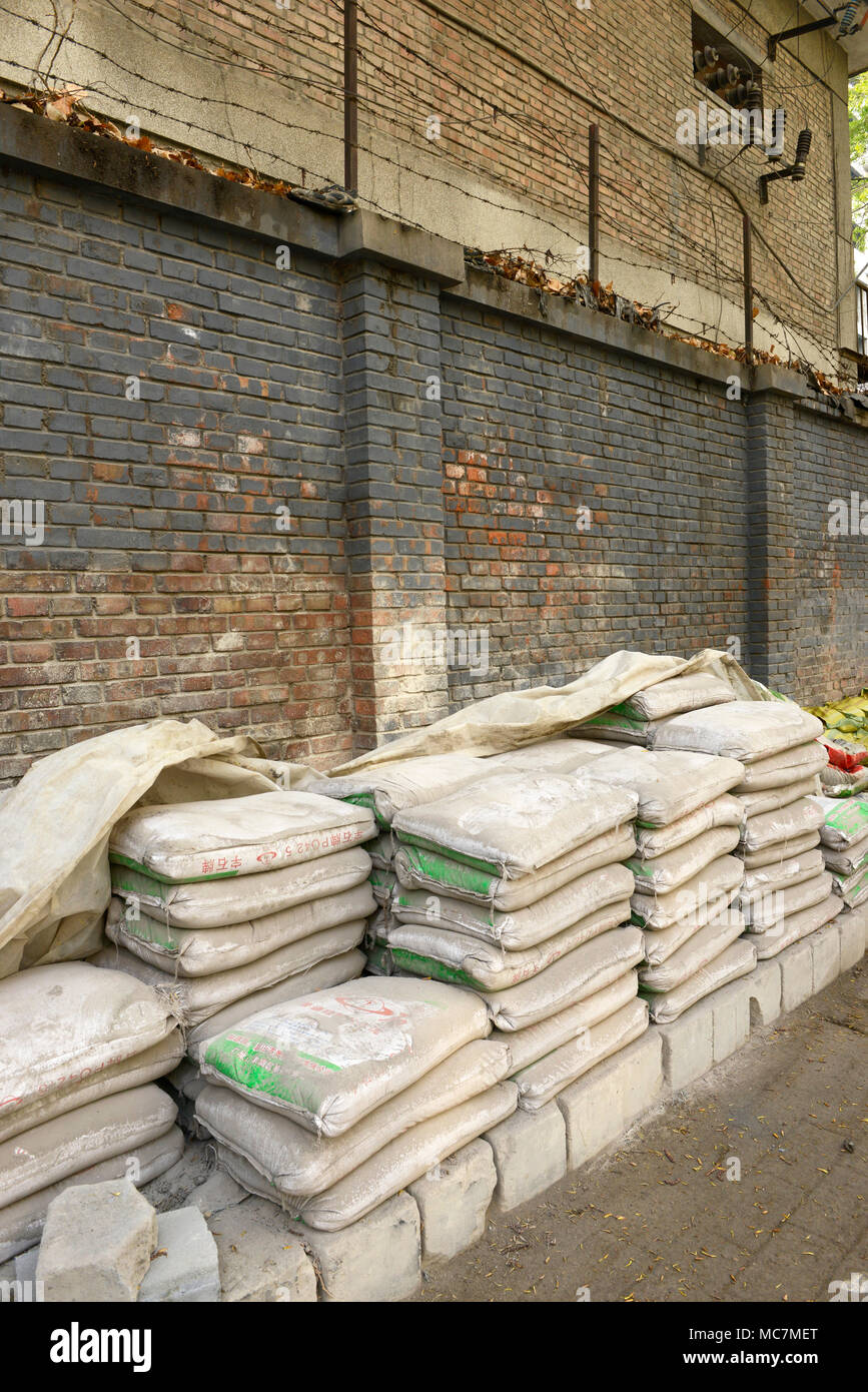 Sacchi di cemento memorizzati nei pressi di un sito di costruzione per uso in locali su piccola scala progetti di costruzione nella parte orientale di Beijing in Cina Foto Stock