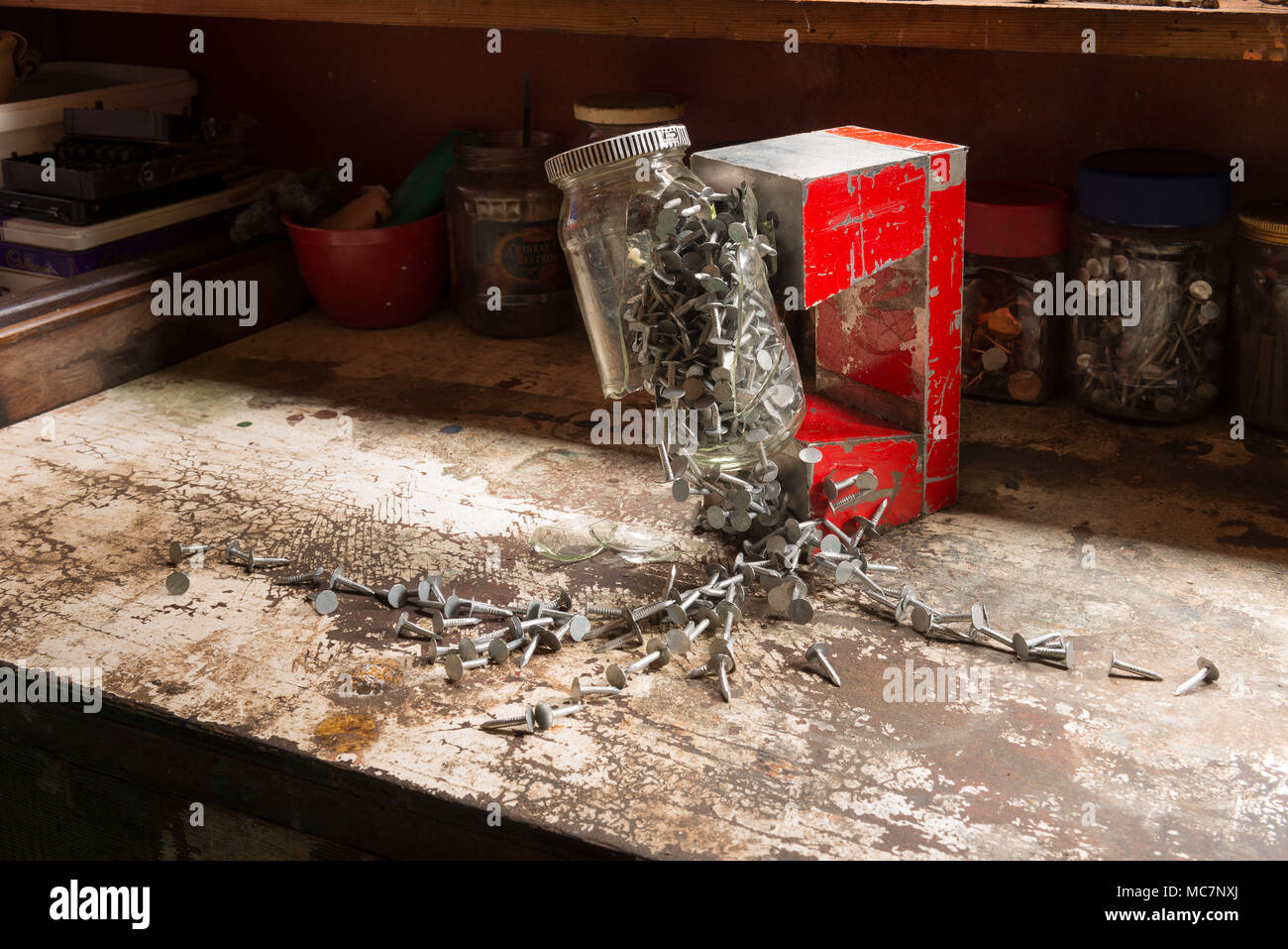 Pericoli di lavorare con magneti, industriale forte magnete attratto un vasetto di vetro di ferro zincato per copertura rampini chiodi così improvvisamente si è rotto il vetro appesi Foto Stock