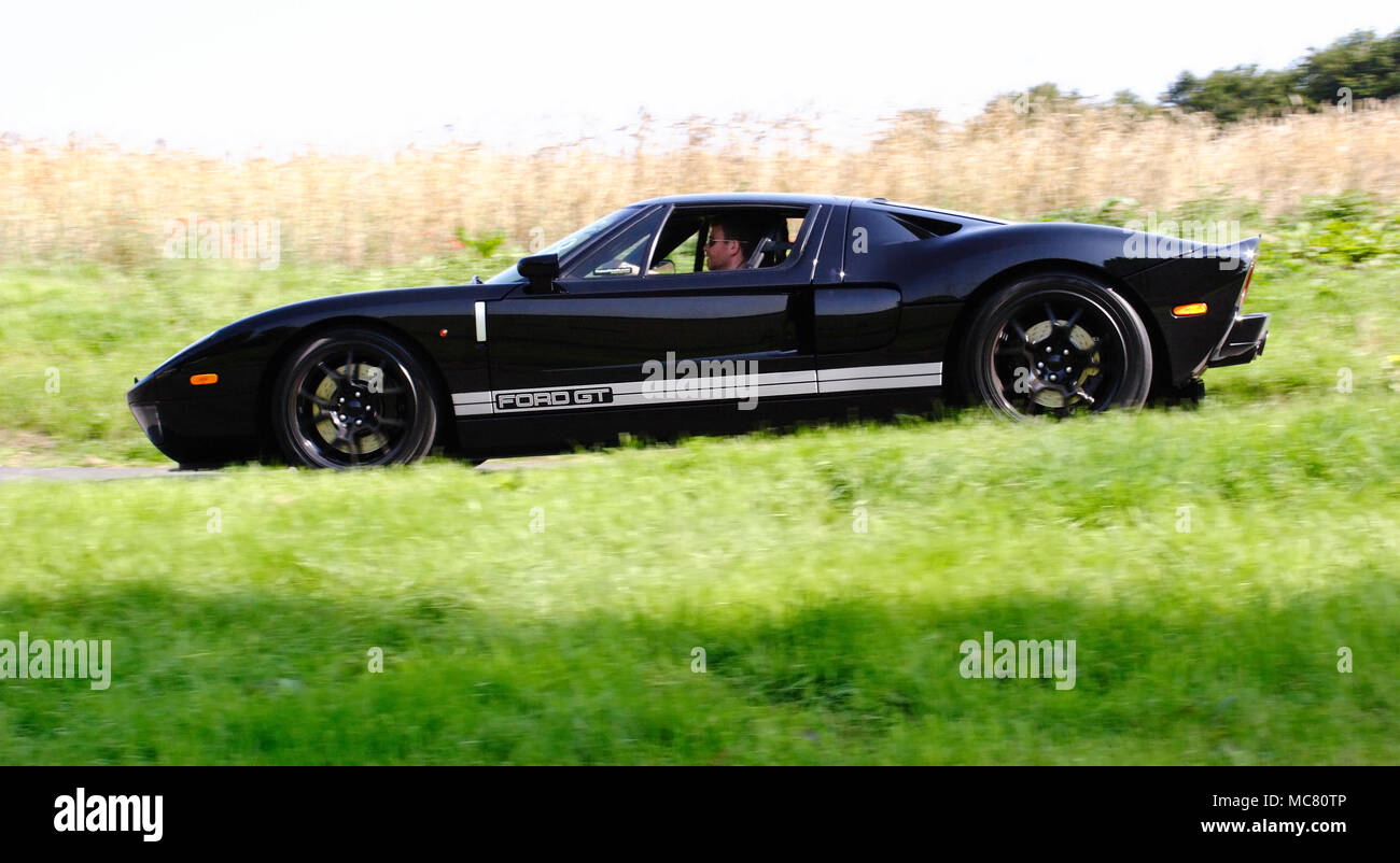 Angolo di basso profilo (vista laterale) di un nero Ford GT Supercar hypercar guida veloce Foto Stock