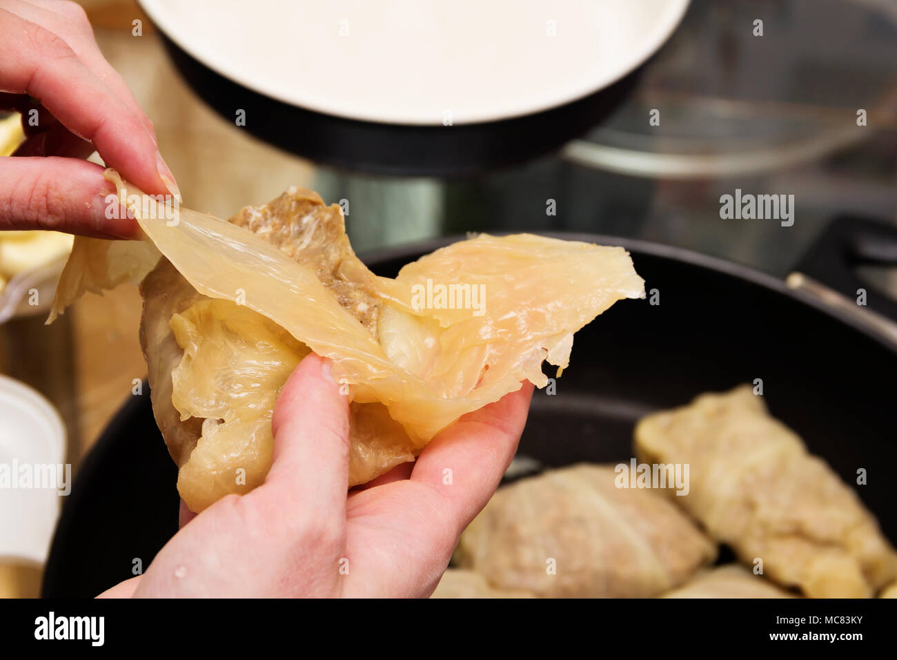 Preparazione di involtini di cavolo. Donna getta la carne macinata in foglie di cavolo. Foto Stock