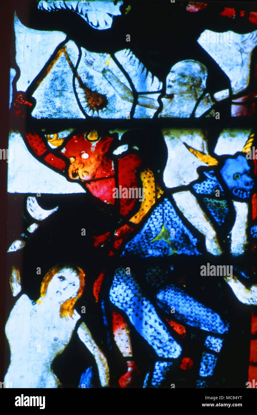 Demoni torturare le anime dei dannati nell Inferno: un demone battendo l anima di una donna con un spiked club. Dettaglio del vetro colorato nella finestra Occidentale della chiesa di St. Mary, Fairford. Circa 1490. Foto Stock
