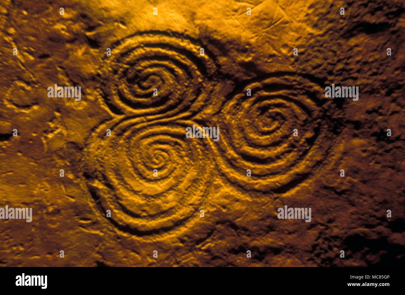 Spirali - Celtic. Tripla spirale formazioni in camera finale del passaggio di epoca preistorica in Newgrange, Irlanda. La sua presenza, così vicino alla spazio culminante dell annuale effetto di luce, suggerisce che questa spirale è collegato con il solare energie. Foto Stock