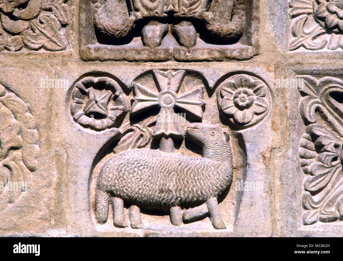 Cristiano l'Agnello di Dio, con i simboli per il sole e la Luna. Dettagli dalla typanum della chiesa medievale di San Michele a Salon, Francia meridionale Foto Stock