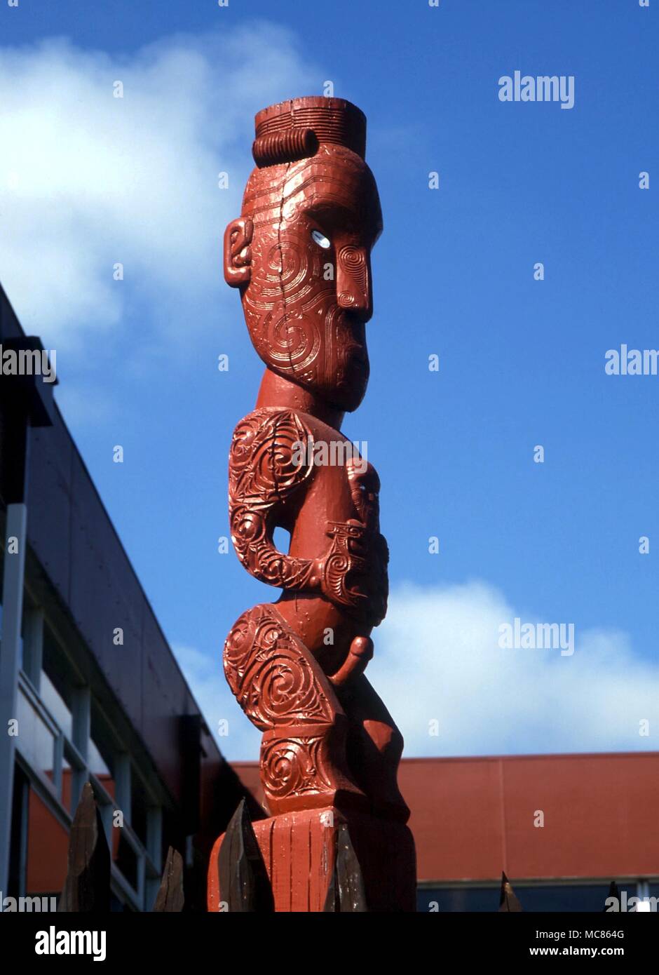 Un MAORI Tekoteko tradizionale (figura scolpita) raffigurante un guerriero, sulla palizzata a Whakarewarewa, Rotorua Foto Stock