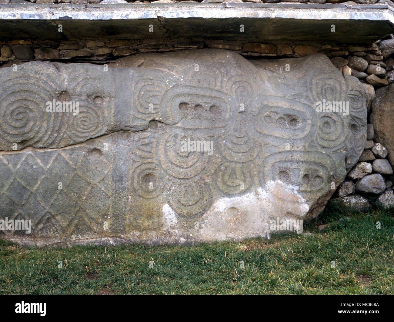 NEWGRANGE (KNOWTH) - Irish sito preistorico. Circa 3.000 BC. Backstone pietra (52), con varie spirale e motivi a losanga. La pietra è diviso, per contrassegnare la linea di solstice Foto Stock