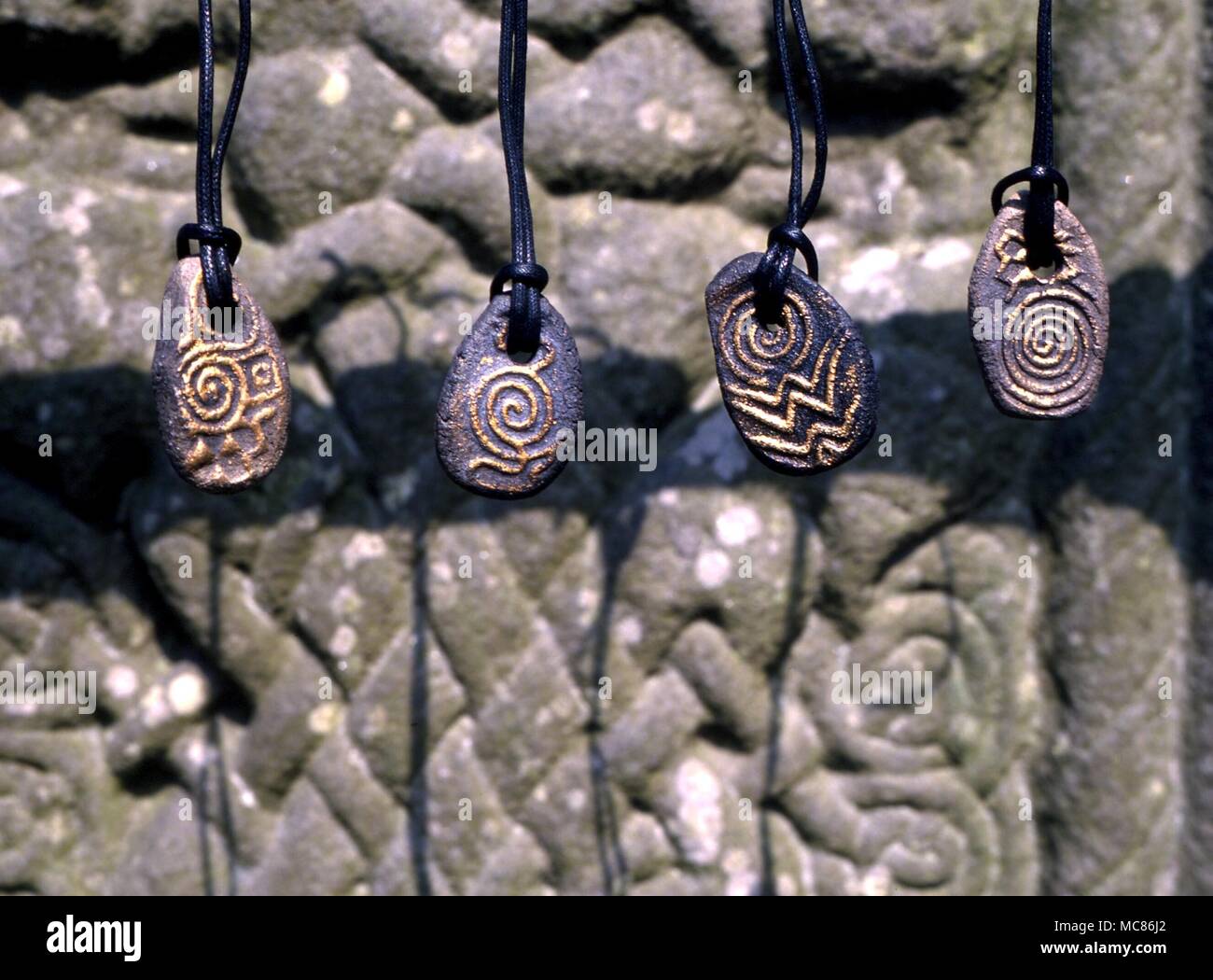 CELTIC Celtic pietre a spirale: amuletic disegni basati su Newgrange, Knowth e Dowth pietra preistorici incisioni (glifi) da luoghi sacri. Appeso sopra lo zoccolo del Celtic Cross a Monasterboice, Irlanda Foto Stock