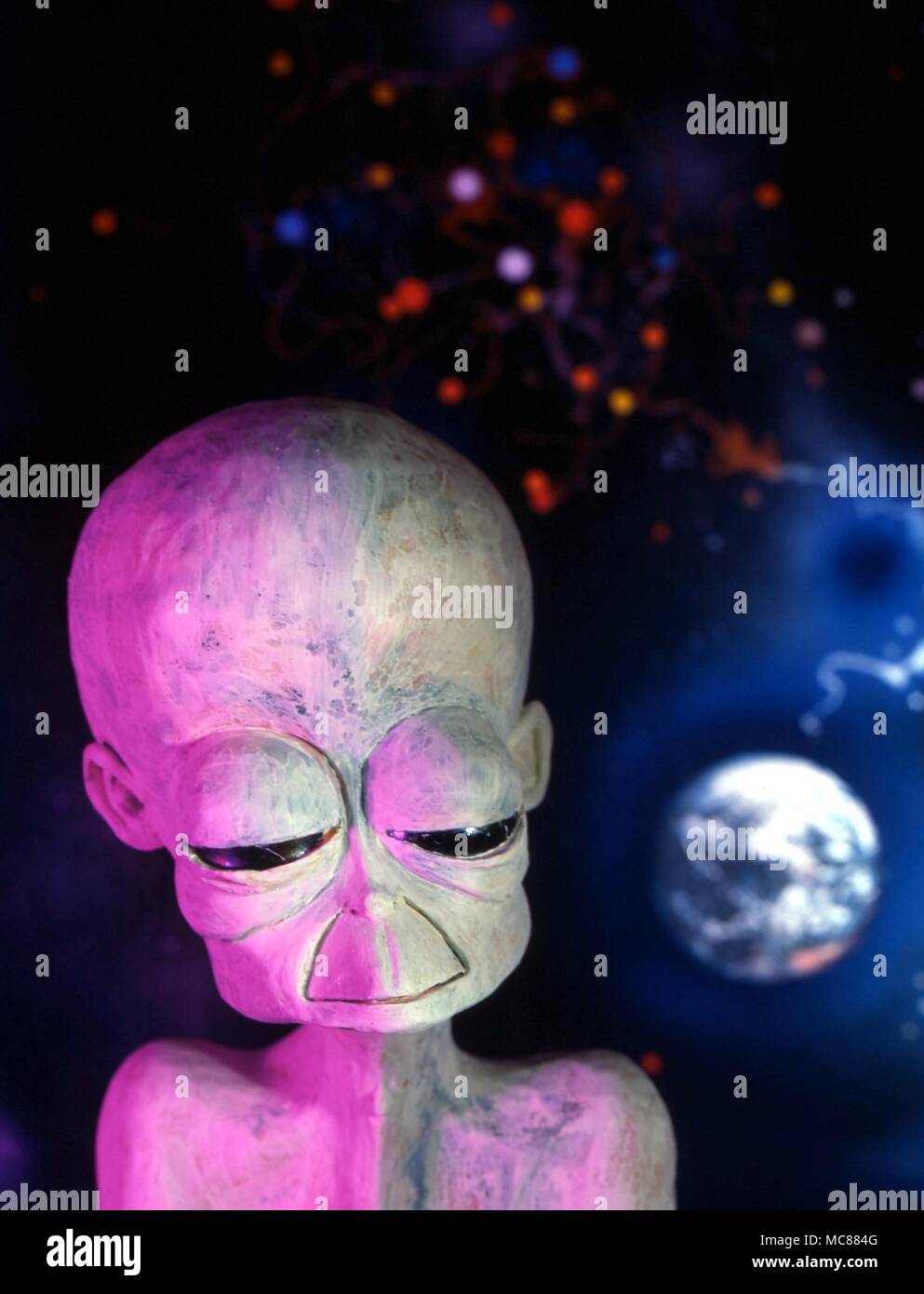 La fantasia. La testa di un alieno spazio uomo contro un fondo cosmico di pianeti e stelle. Foto Stock