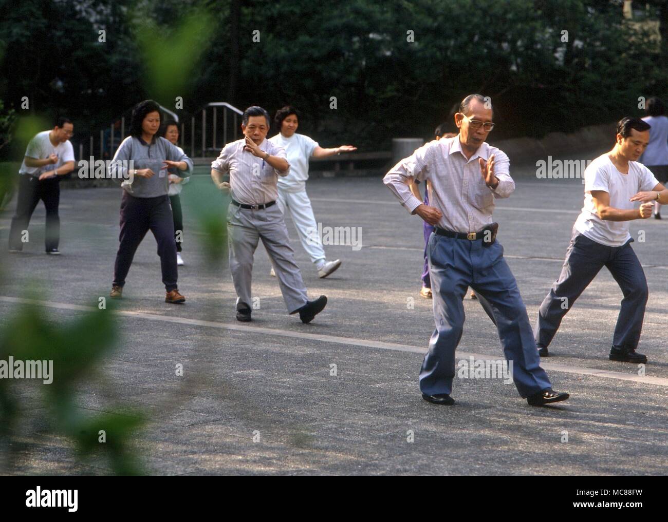 TAI CHI - persone che praticano il Tai Chi con un Master in una Hong Kong park Foto Stock