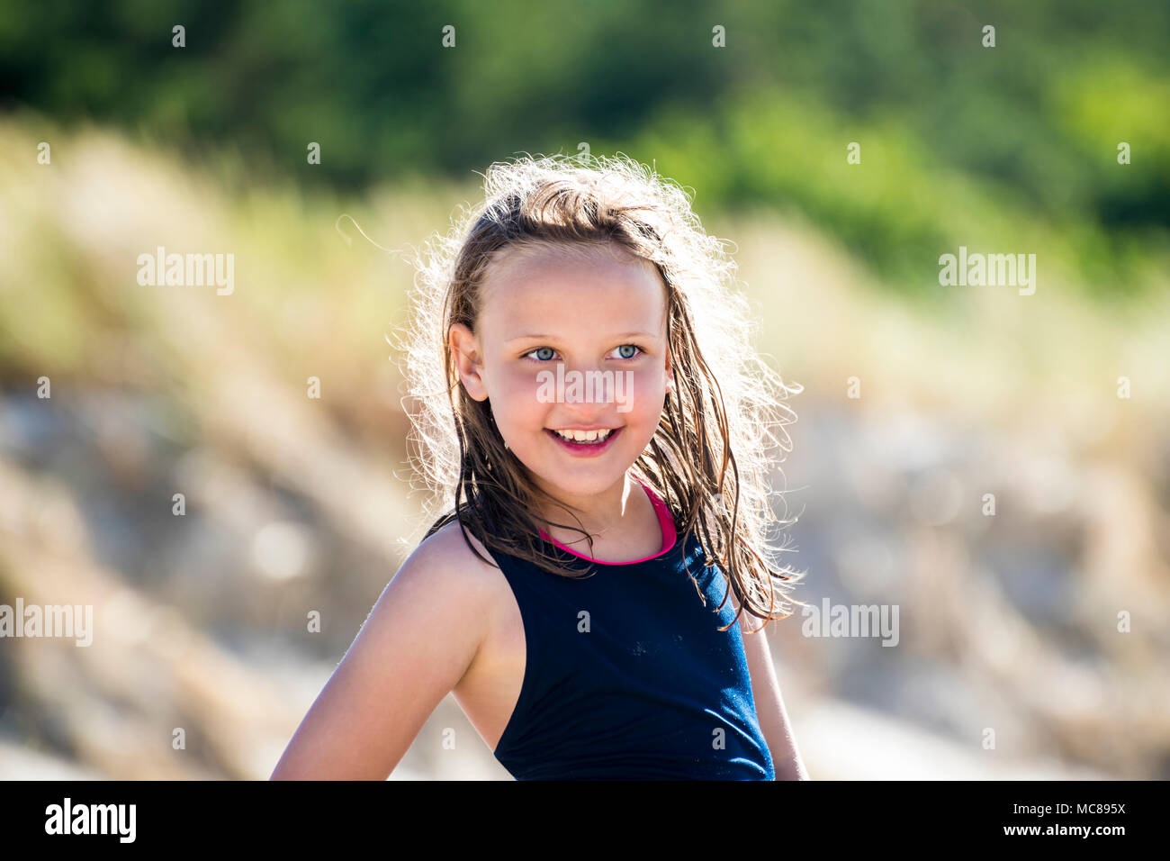 Sorridenti la ragazza della spiaggia, con splendide illuminato i peli bagnati. Foto Stock