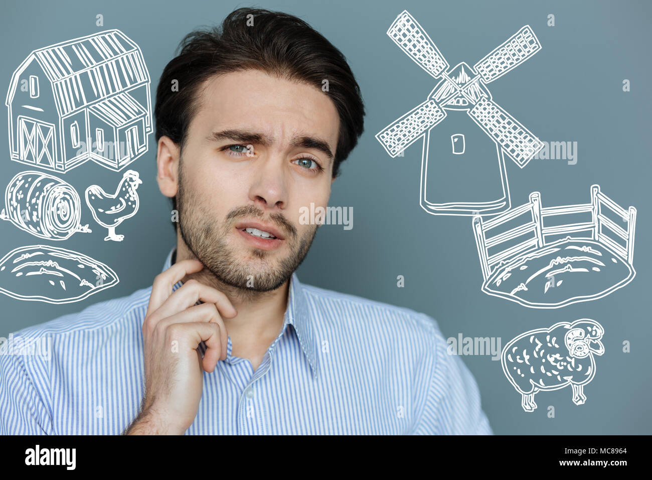 Giovane agricoltore toccando il suo collo mentre pensando al lavoro annullata Foto Stock