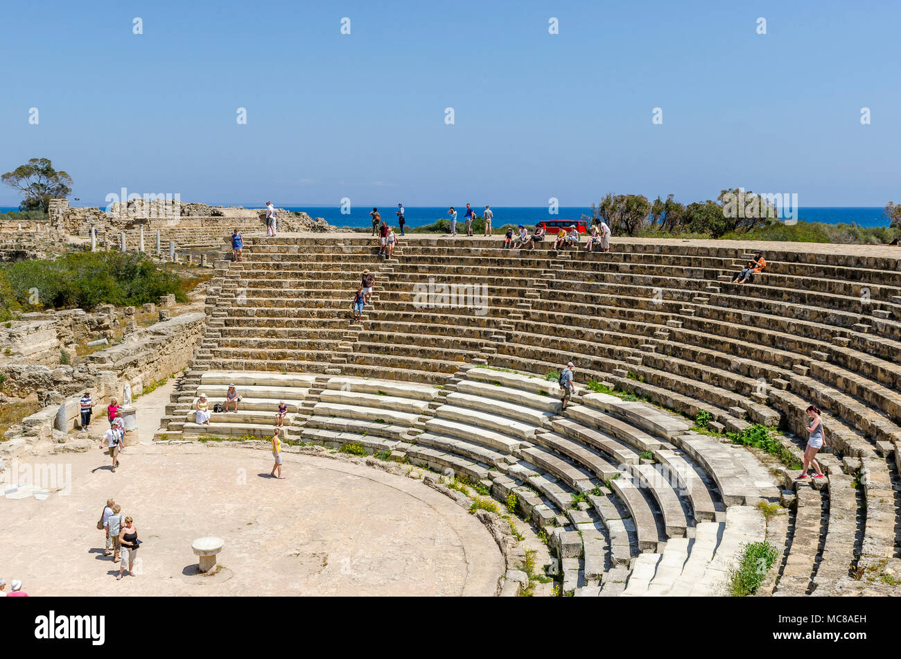 I turisti che visitano l'antico anfiteatro a Salamina sulla costa orientale di Cipro. Foto Stock