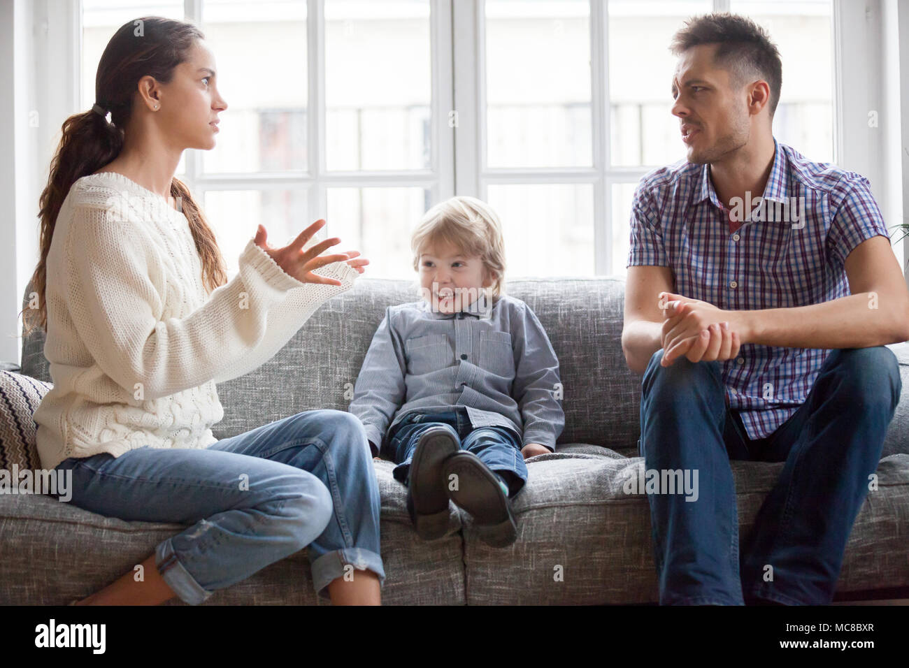 Frustrati ragazzino figlio spaventato con mamma e papà combattimenti a casa, triste ha sottolineato bambino soffre di argomento dei genitori o di un divorzio causando psychol mentale Foto Stock