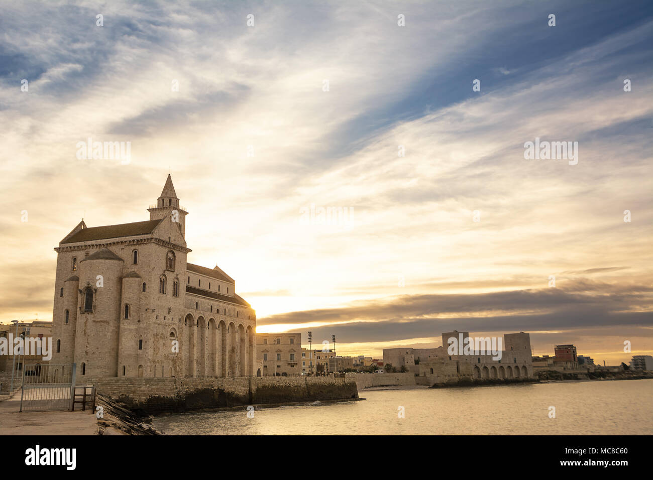 Cattedrale costruita vicino al mare in Puglia al tramonto Foto Stock