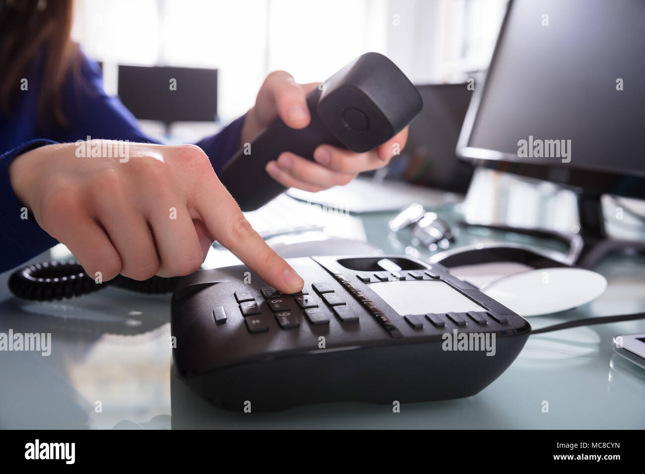 Close-up di un imprenditore la mano di comporre il numero di telefono per effettuare una chiamata telefonica Foto Stock