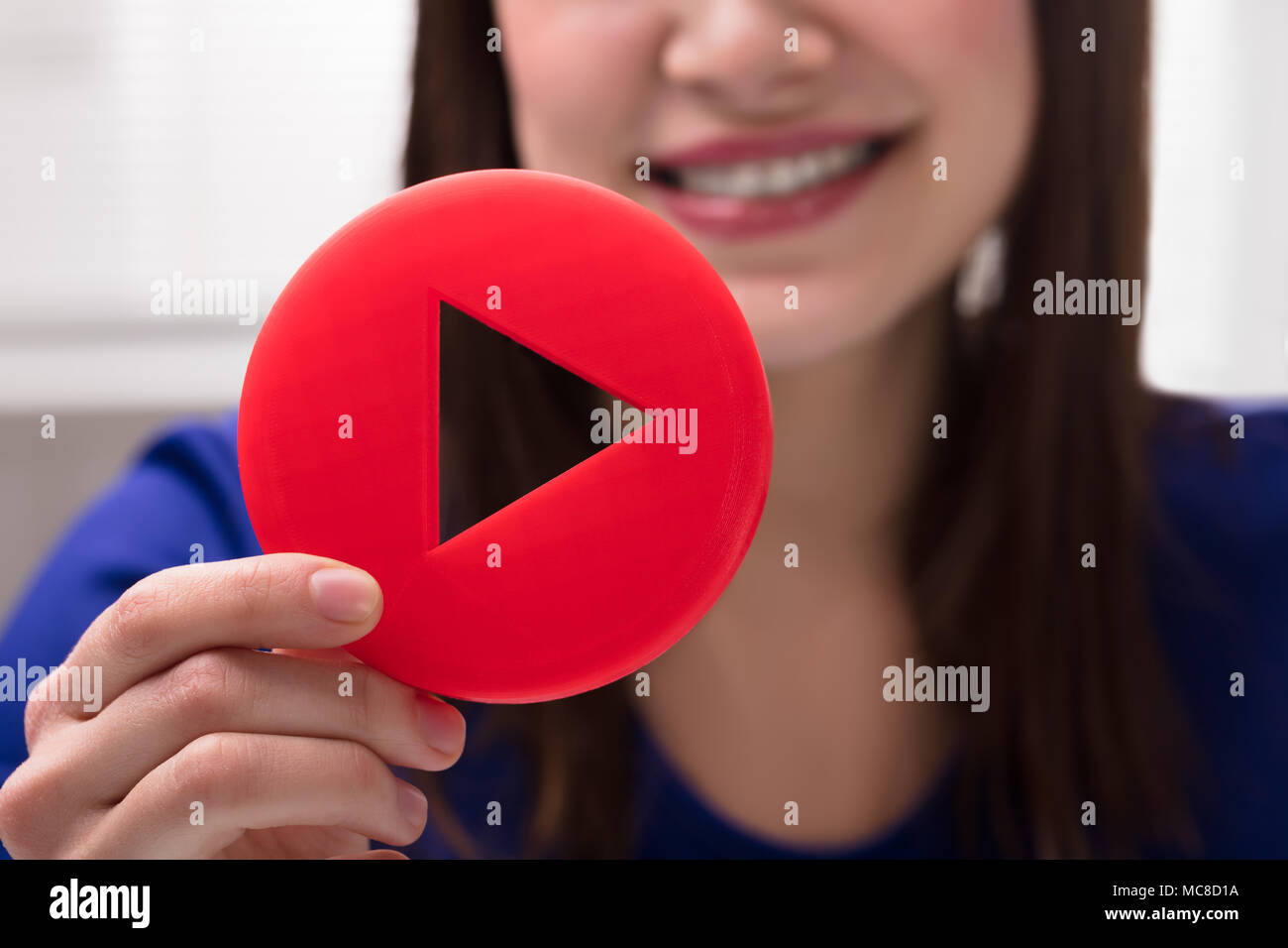 Close-up di una donna di mano azienda Red Icona Riproduci Foto Stock