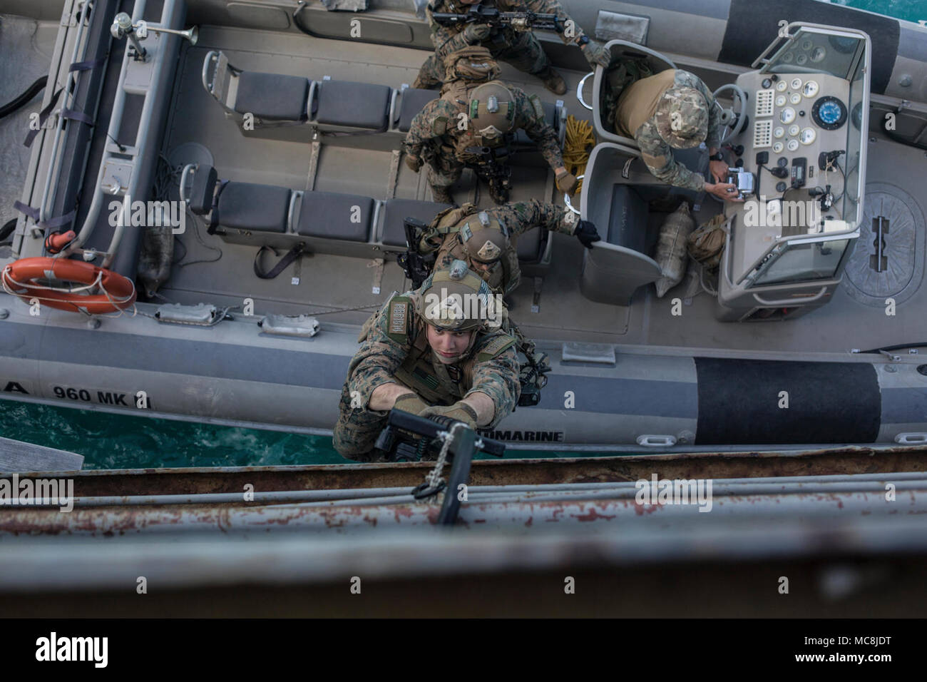 Un U.S. Marine assegnato al marittimo forza Raid (MRF), 26 Marine Expeditionary Unit (MEU), sale una scala di speleologia durante la rigida-scafo gommone inserimento formazione presso la base navale di Souda Bay, Creta, Grecia, 15 marzo 2018. La NATO di interdizione marittima Operations Training Center ha ospitato il MRF la formazione come parte di un due settimane di corso progettato per insegnare di interdizione marittima tecniche per la NATO nazioni partner. Foto Stock