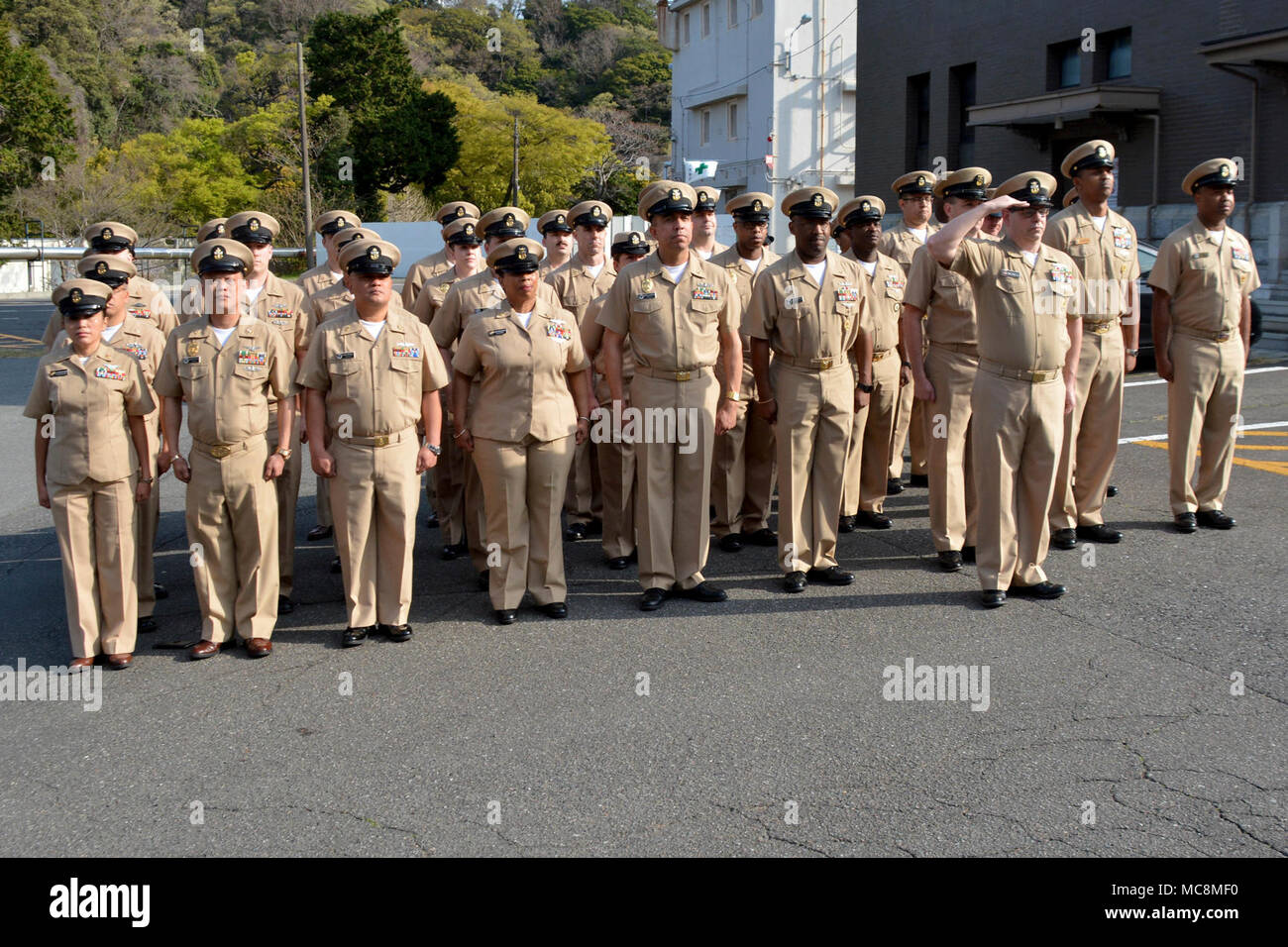 YOKOSUKA, Giappone - Capo Sottufficiali di U.S. Le attività della flotta (FLEACT) Yokosuka e altri comandi di tenant salute durante la mattina i colori per celebrare il 125th compleanno del rango di chief petty officer. FLEACT Yokosuka fornisce, mantiene e gestisce servizi di base e servizi a sostegno del settimo della flotta di inoltro distribuito le forze navali, 71 comandi di tenant, e 27.000 militari e civili. Foto Stock