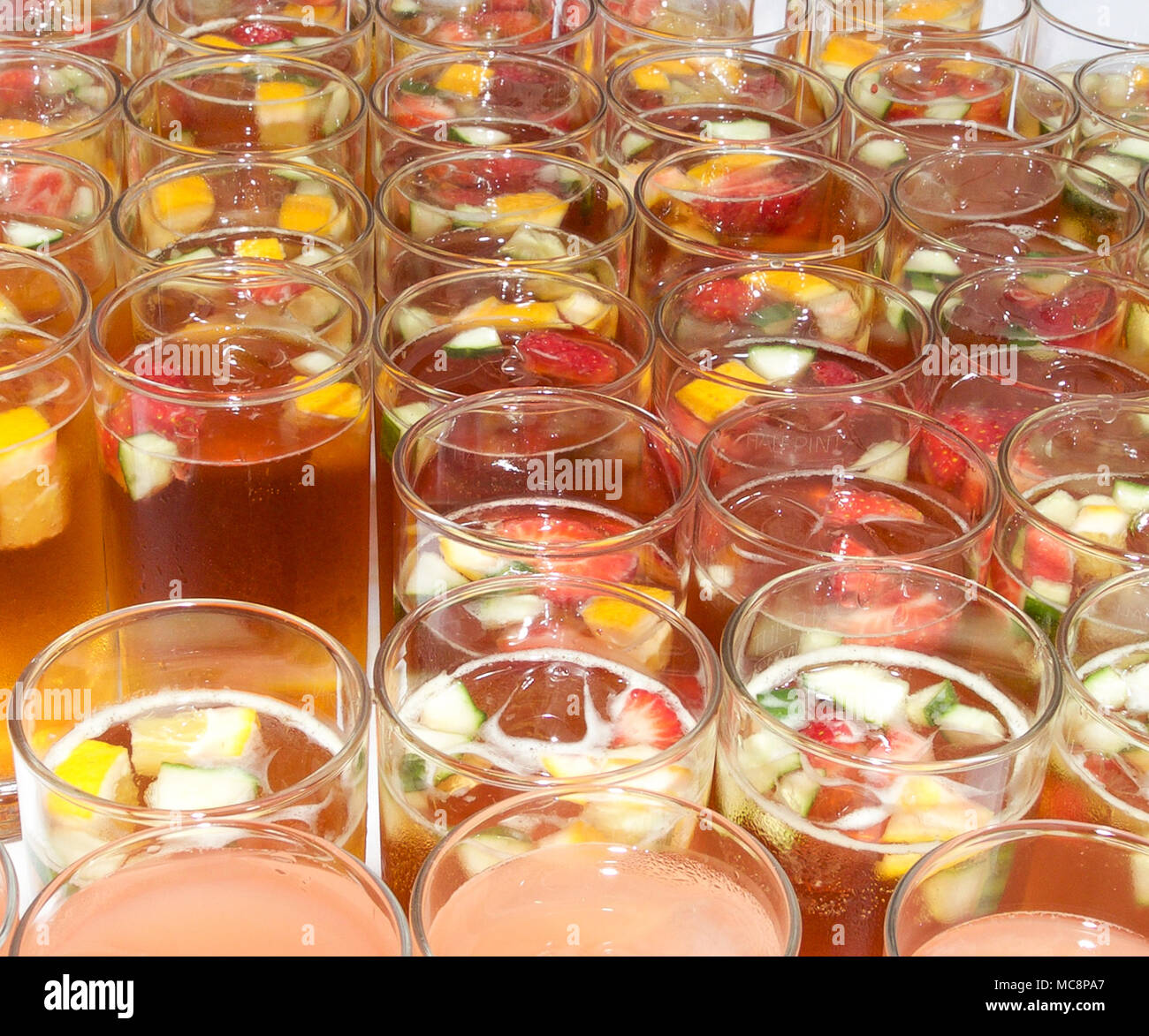 Pimms con frutta estiva e il ghiaccio nel bicchiere alto Foto Stock