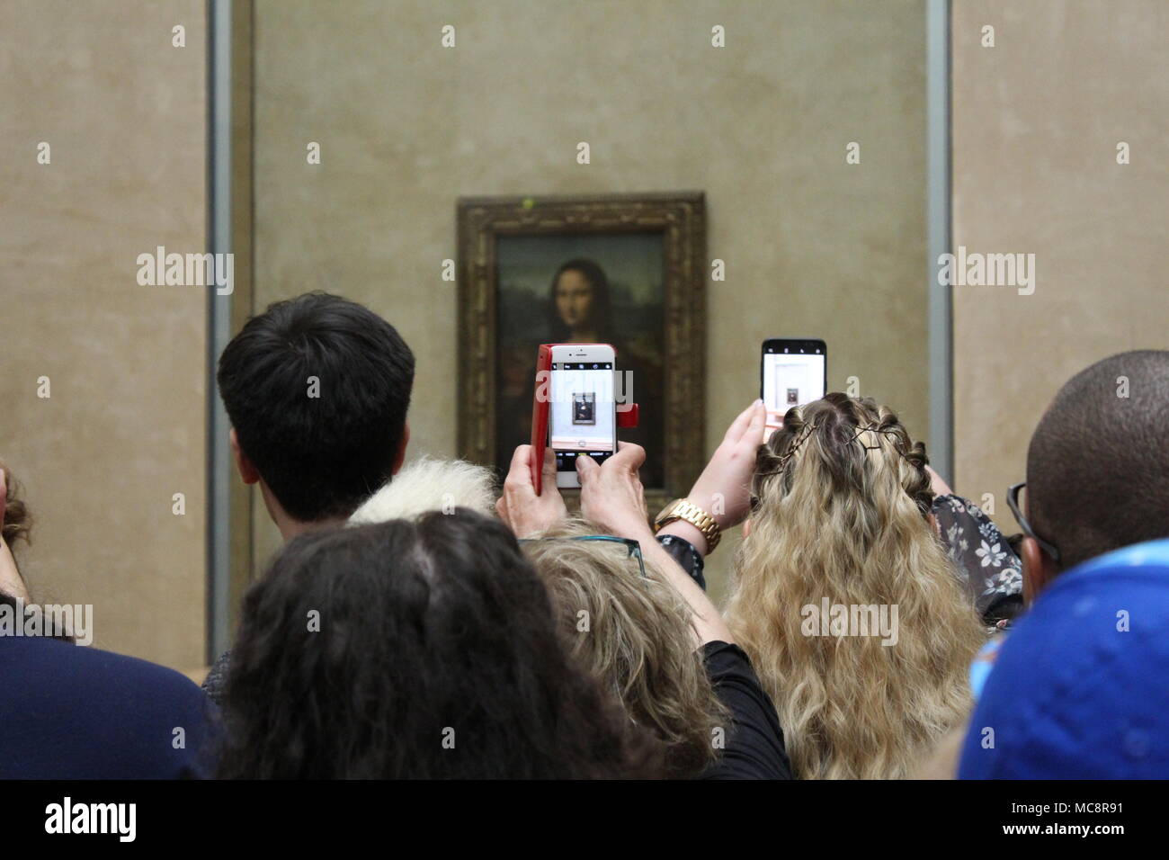 Un gruppo di persone di scattare le foto la Mona Lisa utilizzando i loro telefoni cellulari Foto Stock