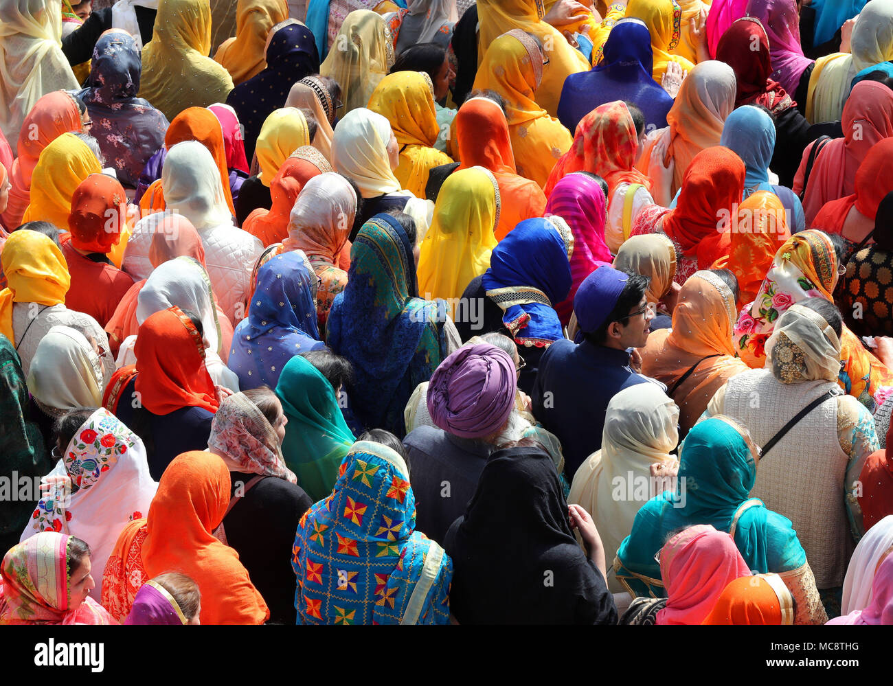 I membri della comunità sikh seguire il Guru Granth Sahib, Sikh libro santo, durante il Nagar Kirtan processione attraverso Anzio, che fa parte del festival Sikh Vaisakhi segnando il raccolto primaverile per gli agricoltori e le comunità nel Punjab in India del nord. Foto Stock