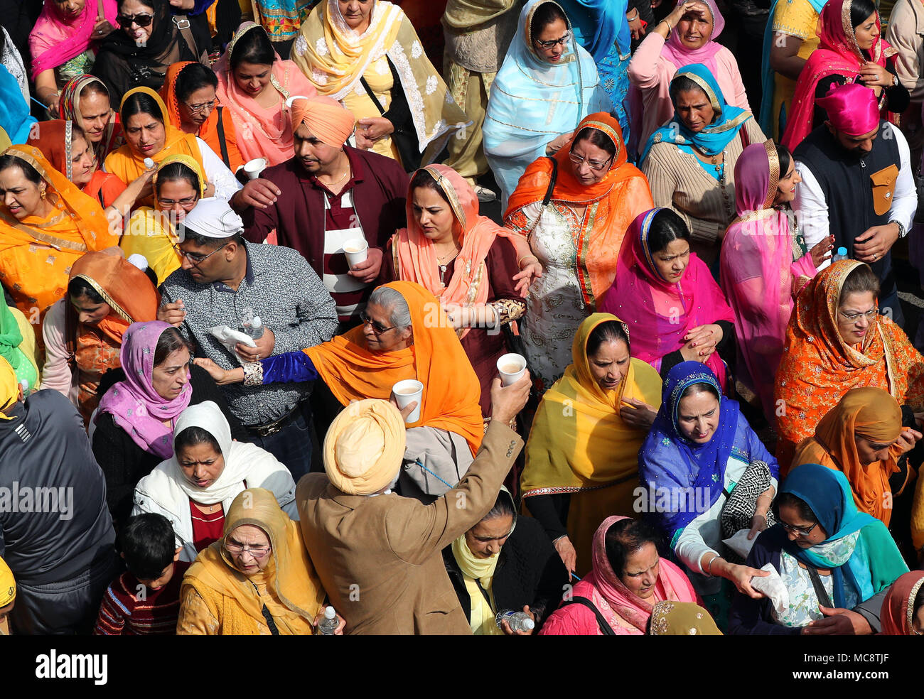 I membri della comunità sikh seguire il Guru Granth Sahib, Sikh libro santo, durante il Nagar Kirtan processione attraverso Anzio, che fa parte del festival Sikh Vaisakhi segnando il raccolto primaverile per gli agricoltori e le comunità nel Punjab in India del nord. Foto Stock