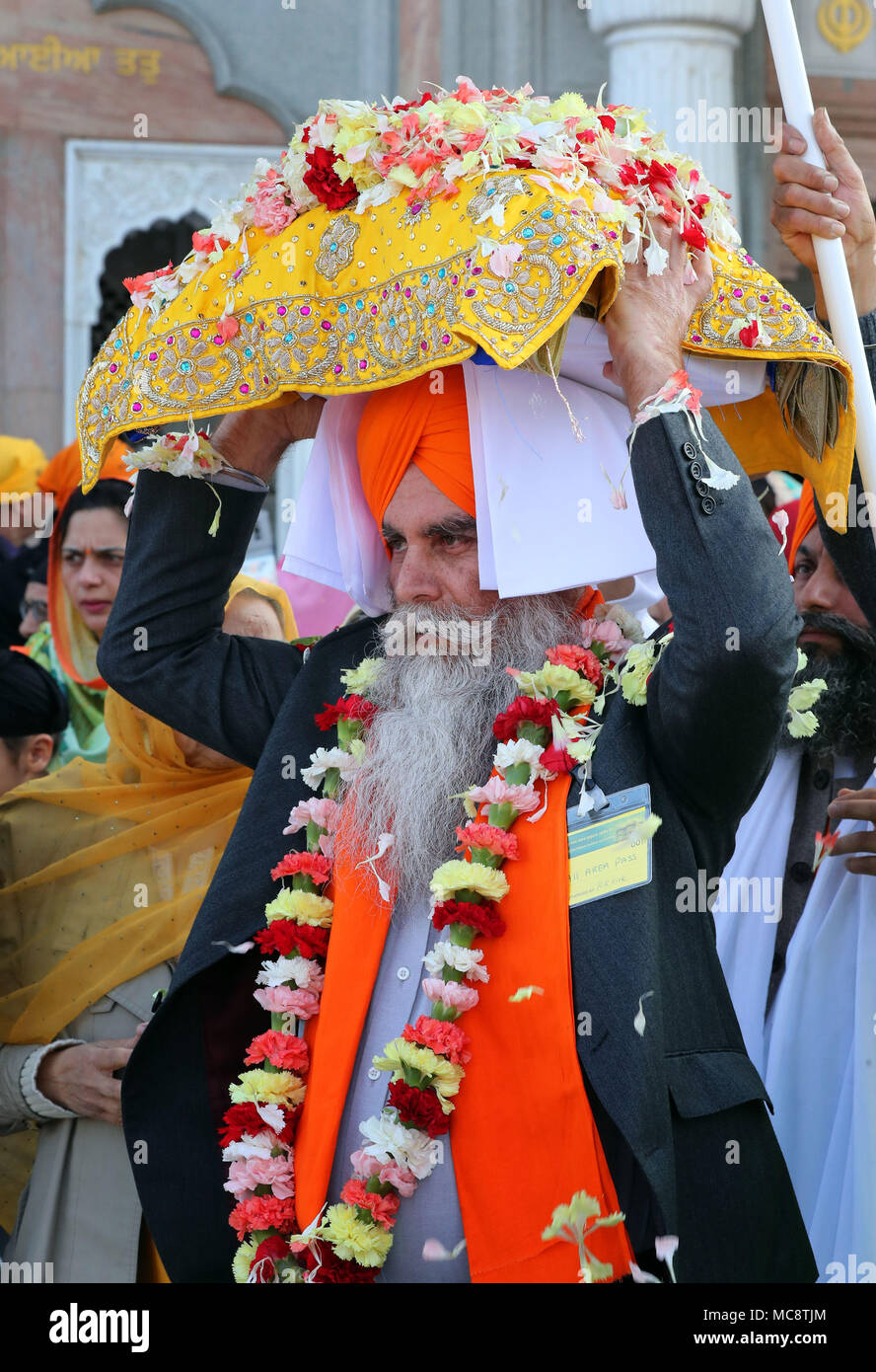 Il Guru Granth Sahib i sikh libro sacro, è portato dal Guru Nanak Gurdwara Darbar tempio durante il Nagar Kirtan processione attraverso Anzio, che fa parte del festival Sikh Vaisakhi segnando il raccolto primaverile per gli agricoltori e le comunità nel Punjab in India del nord. Foto Stock