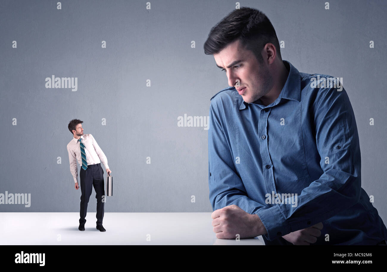 Giovane imprenditore professionale essendo arrabbiato con un altro imprenditore in miniatura Foto Stock