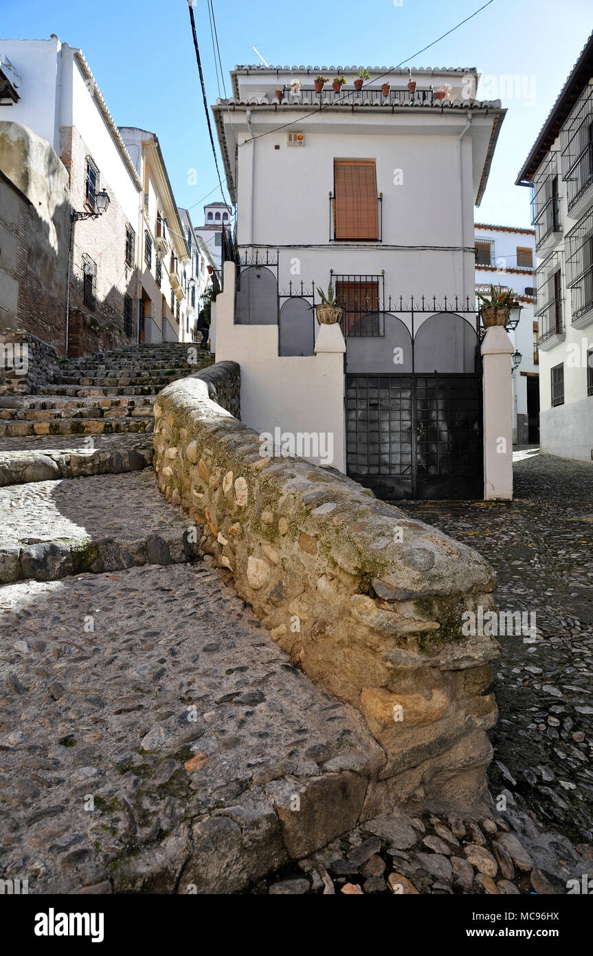 Vecchia strada medievale con pavimentazione in pietra e le scale e il bianco tipico vecchie case all'Albaicín quartiere arabo di Granada (Andalusia, Spagna) Foto Stock