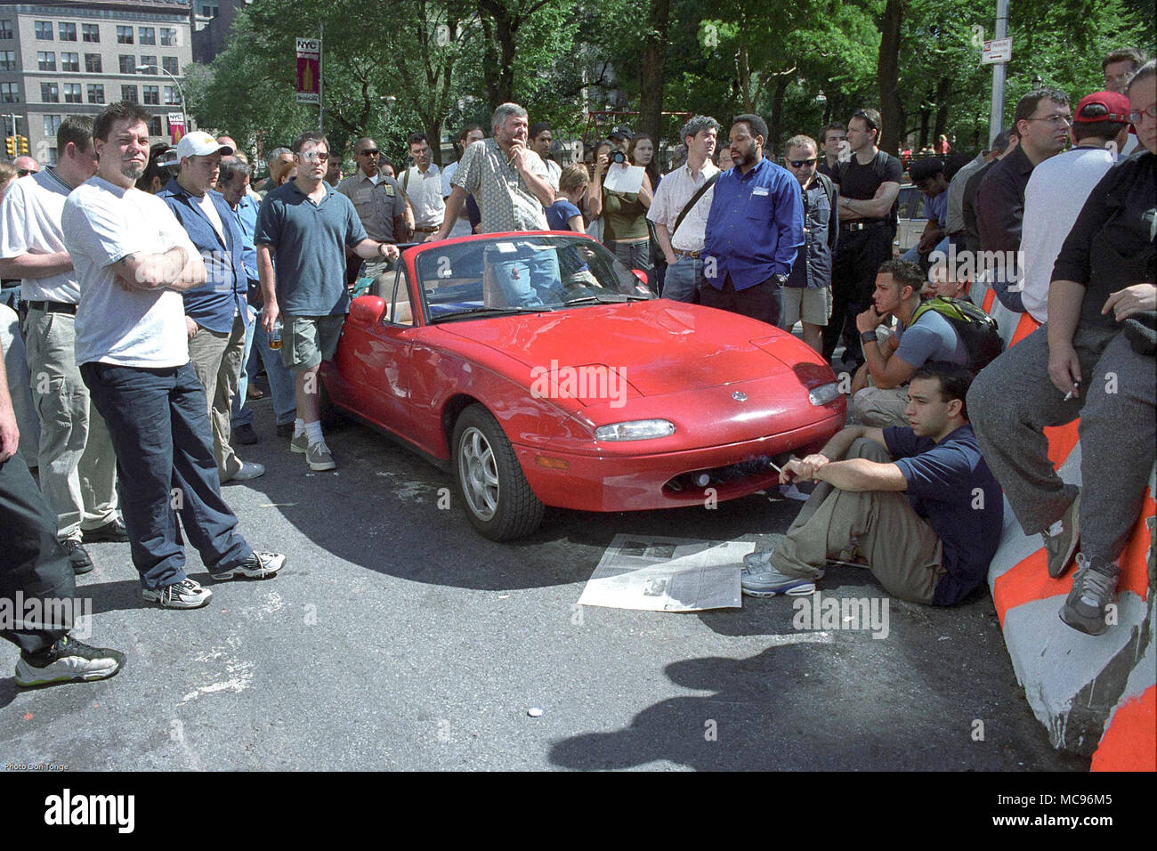 I Newyorkesi stand in stato di shock e incredulità ascoltando le ultime notizie e gli aggiornamenti su una macchina parcheggiata radio, poche ore dopo gli attentati terroristici al World Trade Center di New York City su 9/11 fotografia DON TONGE Fotografo Foto Stock
