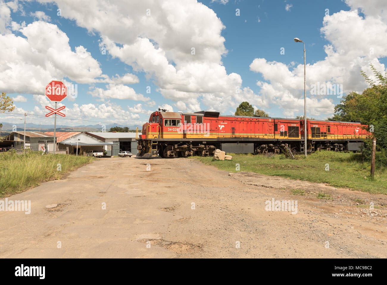 FICKSBURG, SUD AFRICA - 12 Marzo 2018: un treno attraversare una strada piena di buche in Ficksburg nel libero Stato Provincia Foto Stock