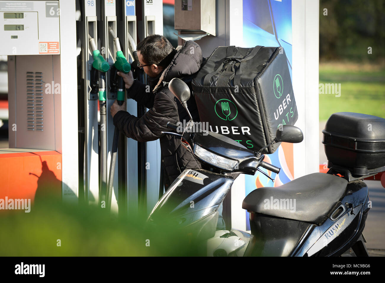 Un Uber mangia il lavoratore di consegna è visto il rifornimento di carburante il suo scoorter a Varsavia in Polonia il 14 aprile 2018. Foto Stock