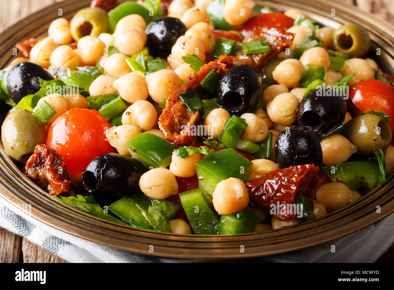 Medio Oriente Insalata di fagioli (Balela) con ceci, pomodori, cipolle, olive ed erbe macro su una piastra. Posizione orizzontale Foto Stock