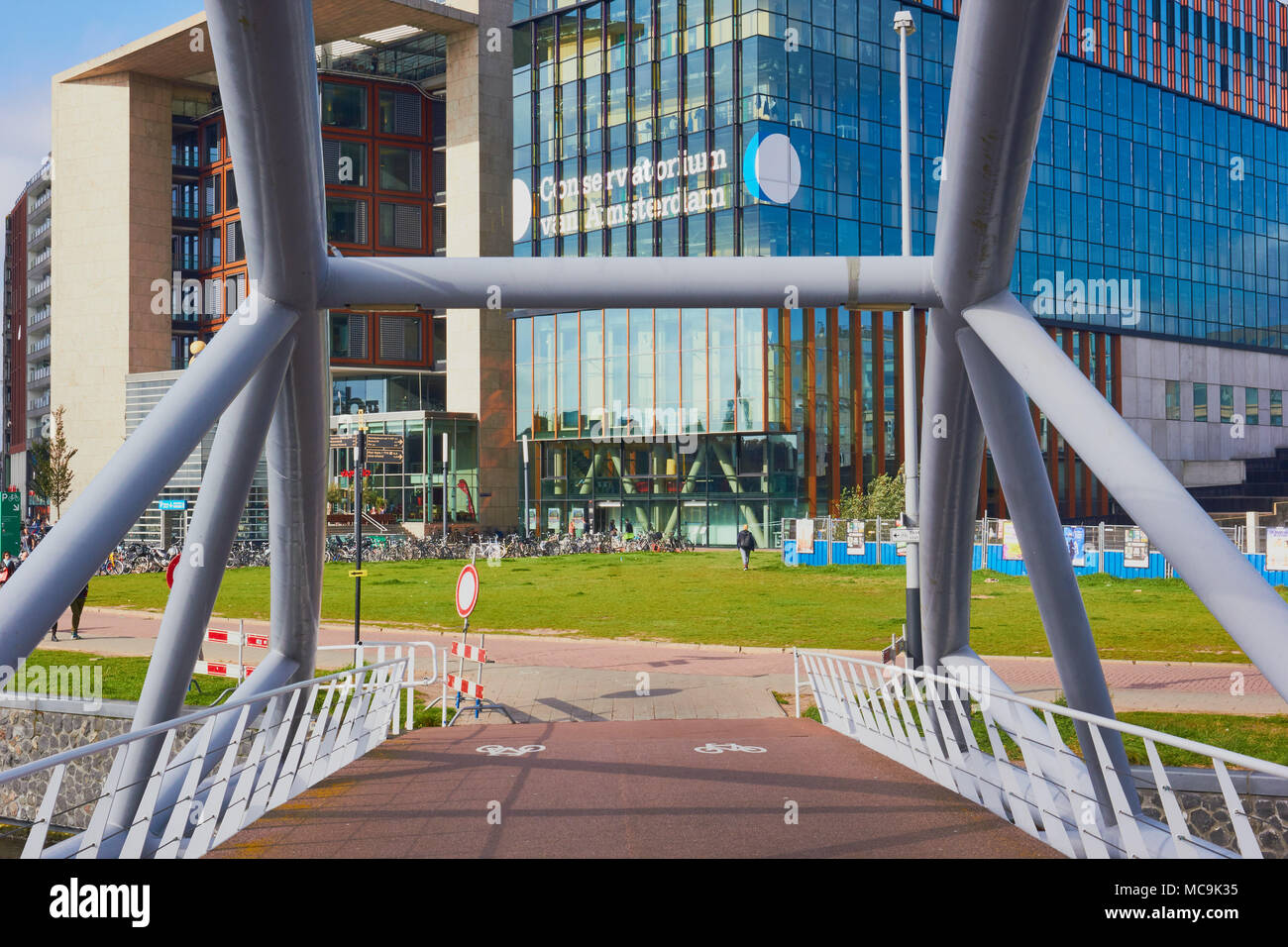 Ponte guardando verso Conservatorium van Amsterdam, Oosterdokseiland (Eastern Docklands), Amsterdam, Paesi Bassi. Foto Stock