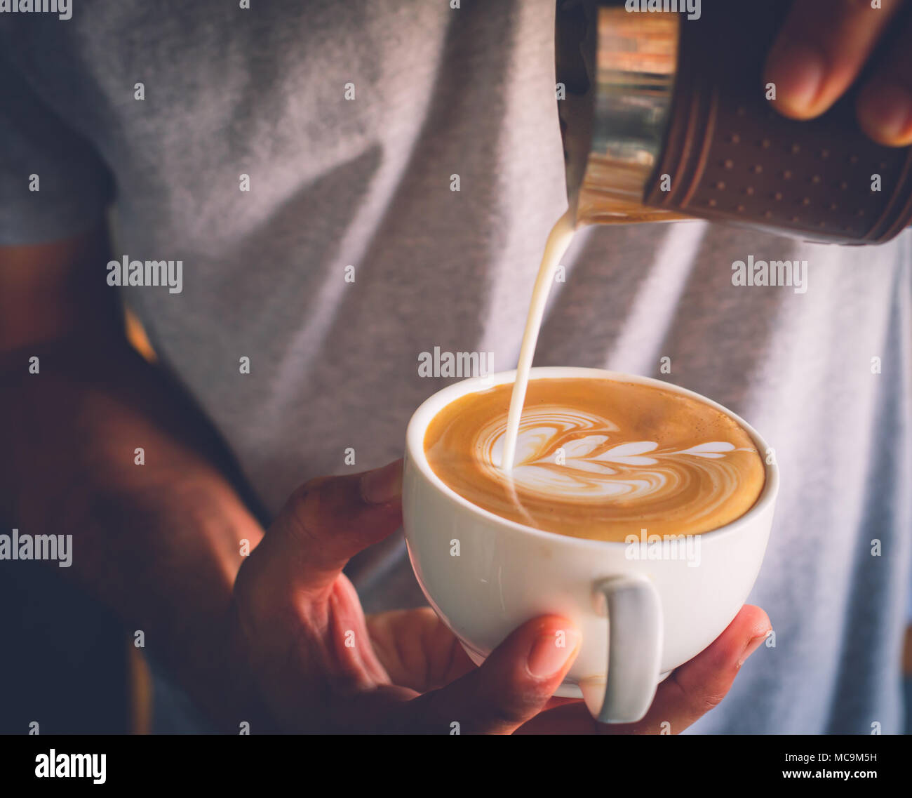 Barista versando il latte per il caffè. Latte art. Come fare il caffè latte Foto Stock