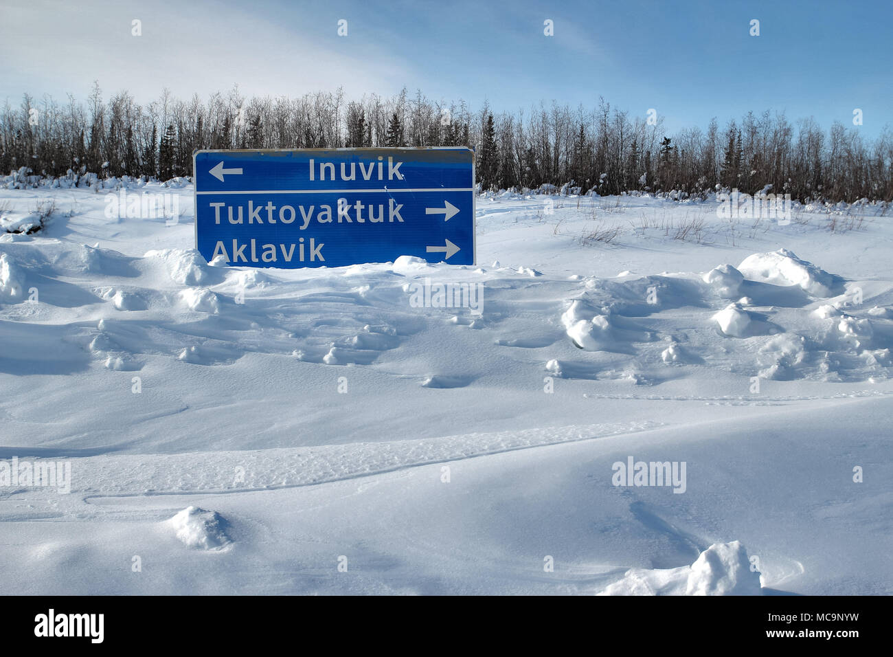 Cartello stradale sepolto nella neve, lungo la strada di ghiaccio invernale per le comunità sub-artiche di Inuvik, Tuktoyaktuk, e Aklavik, territori del Nord-Ovest, Canada. Foto Stock