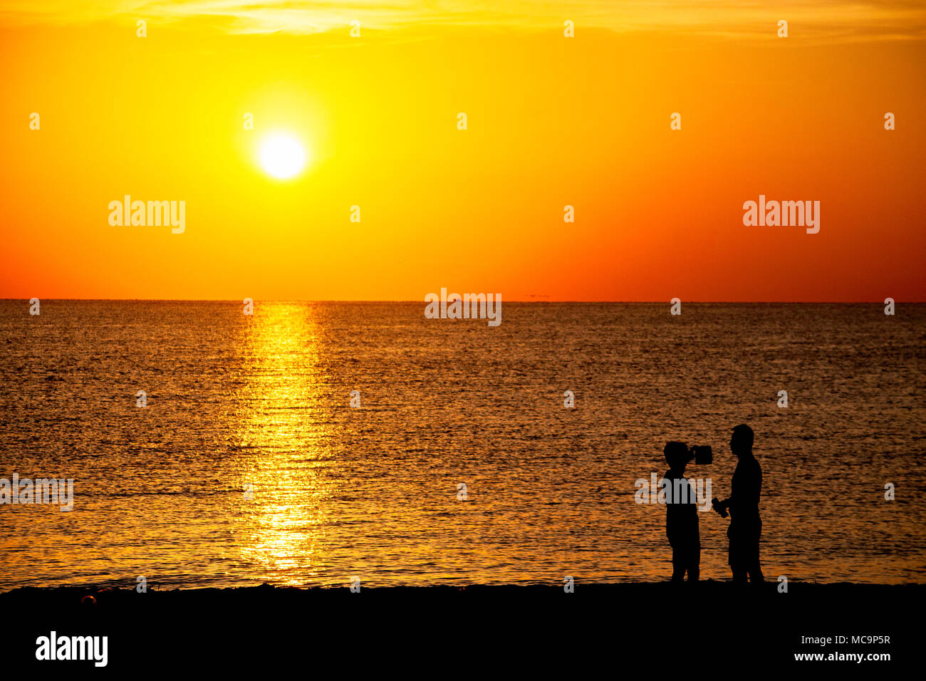 Coppia sulla spiaggia che posano per una foto e godendo la mattina Florida sunrise Foto Stock