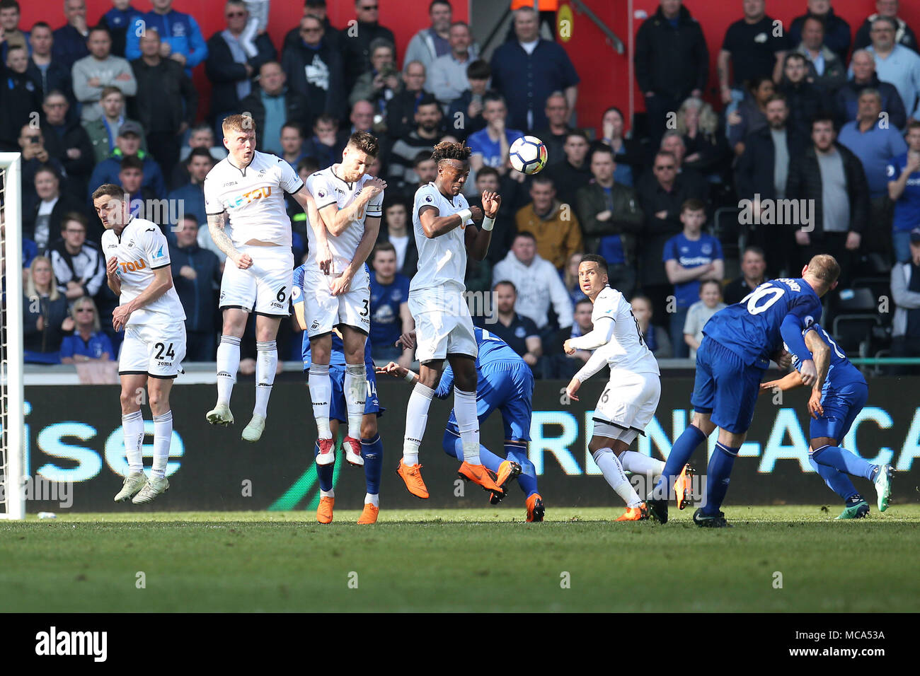 Galles del Sud, Regno Unito, 14 aprile 2018. Wayne Rooney di Everton ® hits di un calcio di punizione a scopo al di sopra del Swansea City wall e ampia. Premier League, Swansea City v Everton al Liberty Stadium di Swansea, Galles del Sud sabato 14 aprile 2018. Questa immagine può essere utilizzata solo per scopi editoriali. Solo uso editoriale, è richiesta una licenza per uso commerciale. Nessun uso in scommesse, giochi o un singolo giocatore/club/league pubblicazioni. Credito: Andrew Orchard fotografia sportiva/Alamy Live News Foto Stock