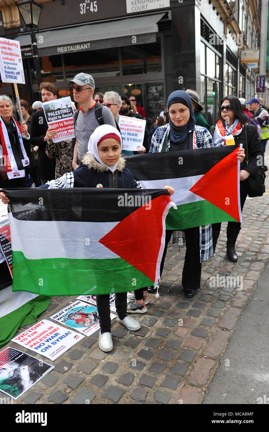 Londra, UK 14 aprile 2018 ragazzina musulmana e sua madre holding bandiere palestinese a diritti palestinesi demo di fronte alla ambasciata di Israele in Kensington, London, Regno Unito. La leggermente chiassosa dimostrazione è stata ragionevolmente ben supportato con circa 60 persone presenti. È stato chiamato per protestare contro la continua tensione nella striscia di Gaza a seguito dei recenti atti di violenza tra i due lati. Londra, UK 14 aprile 2018 raccolta di cinque pro-Israele contestatori heckled la dimostrazione dall'altro lato della strada. Credito: Michael Preston/Alamy Live News Foto Stock