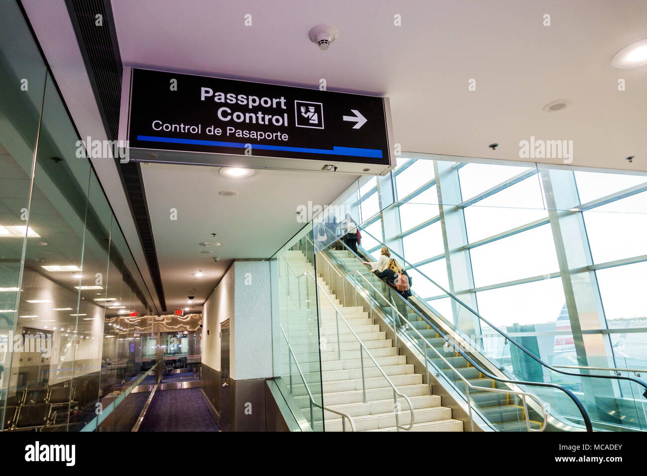 Miami Florida,International Airport mia,controllo passaporti,cartello,bilingue,spagnolo inglese lingua,scala mobile,scale,passeggeri passeggeri motociclisti,FL Foto Stock