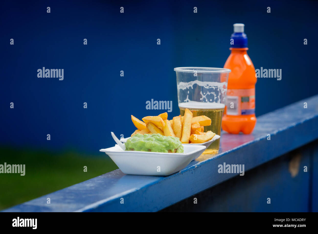 In una partita di calcio il 14 aprile 2018 un uomo con il suo figlio ha avuto alcuni chip, una torta con piselli una pinta di lager e una bevanda a base di frutta Foto Stock