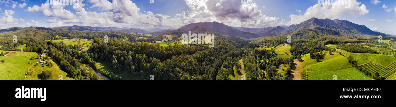 Ampio panorama elevati di Dorrigo Parco Nazionale Monti sulla verde valle coltivata lungo il fiume Bellinger con aziende agricole e di agricoltura per le aziende Foto Stock