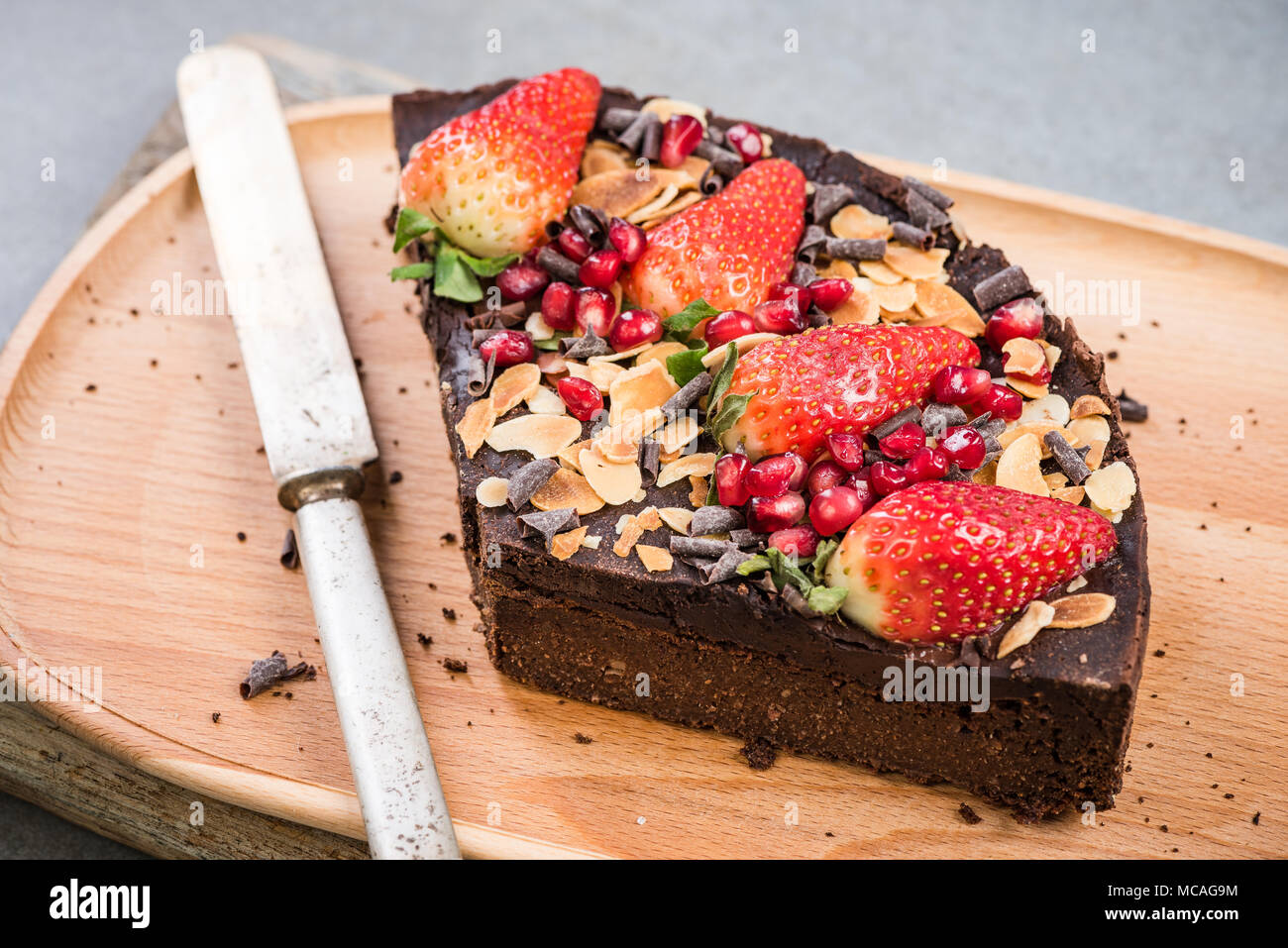 Fetta di sano brownie con fragola e melograno seme. Foto Stock