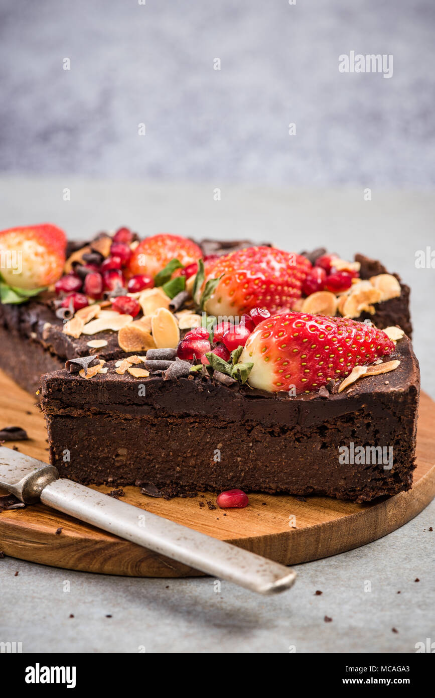 Una sana brownie decorata con bacche e semi di melograno. Foto Stock