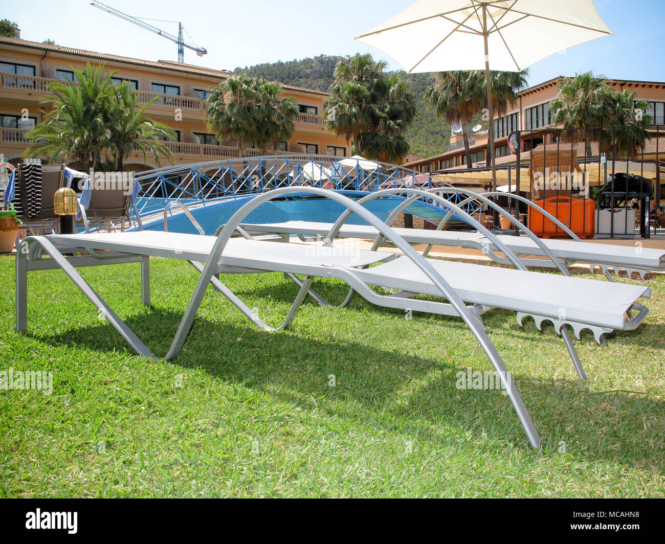 Sedie a sdraio vicino a una piscina in una vacanza spagnola hotel Foto Stock