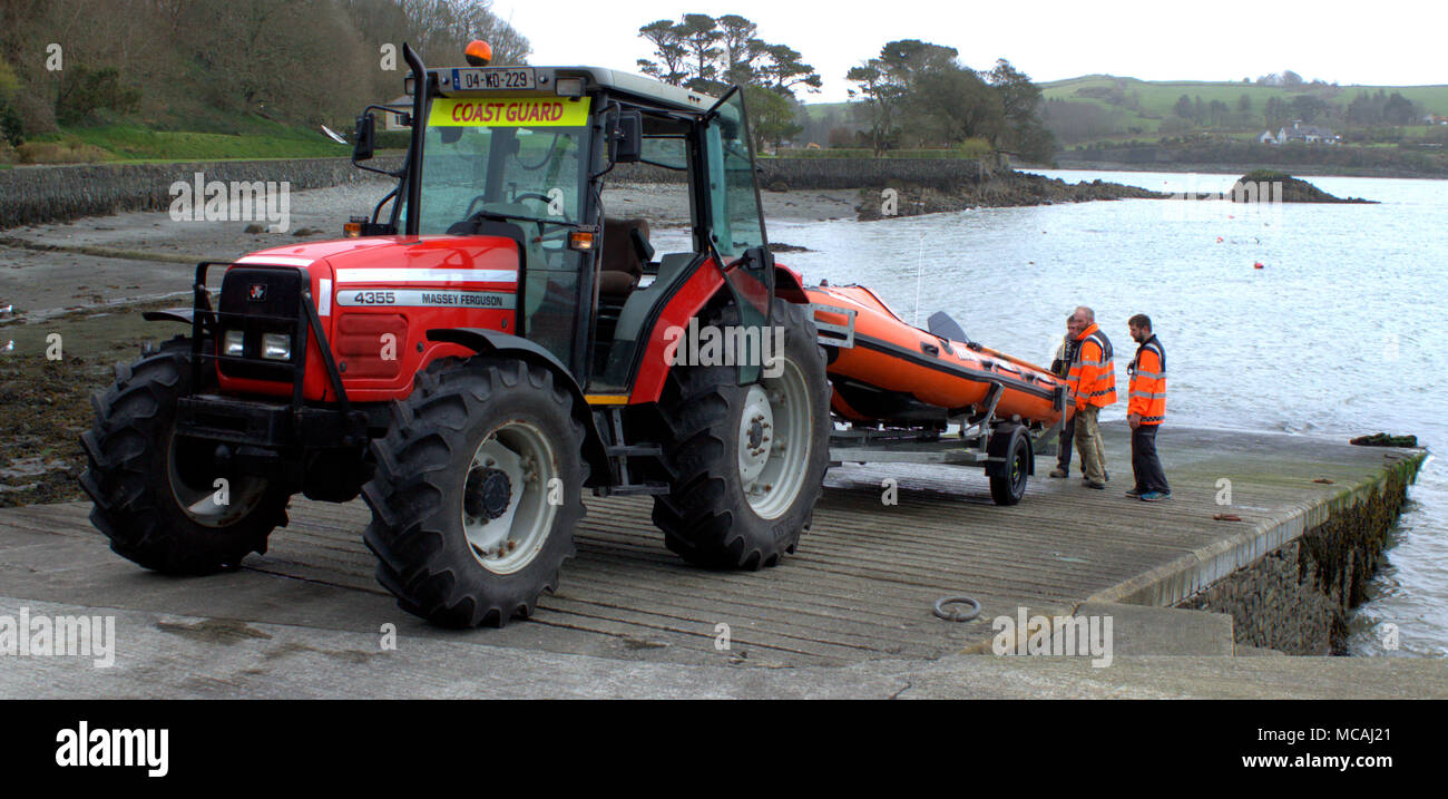 Irish coast guard sbarcano le loro piccole imbarcazioni di salvataggio costiera su un rimorchio e trasportato fino la scalo da un trattore Massey Ferguson. Foto Stock