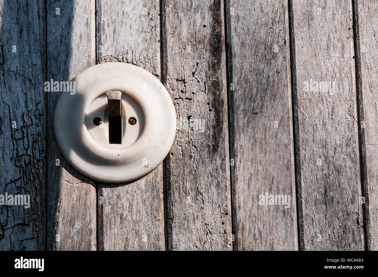 Vecchia luce elettrica switch su una parete in legno Foto Stock